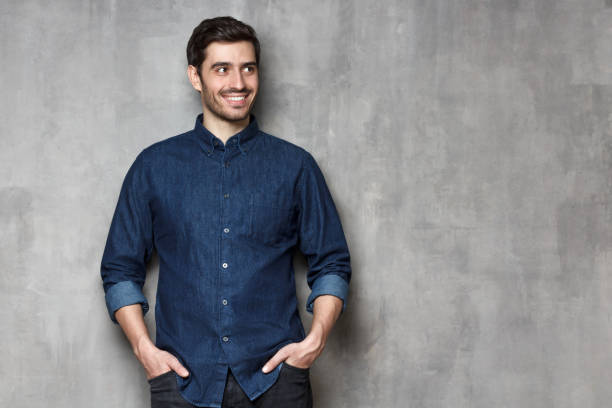 istock Relaxed stylish guy smiling happily while having rest, isolated on gray textured wall 1150254220