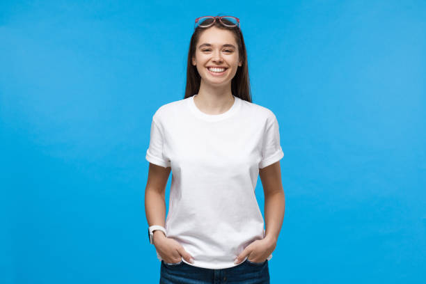 白い t シャツを着た若い笑顔の女性, 青の背景に分離 - i t ストックフォトと画像