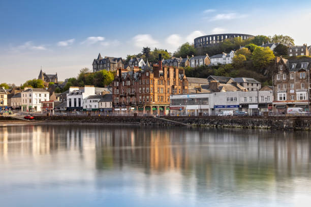 Scenic View over Oban in Scotland The Harbour of Oban and the Mccaig's Tower reflecting in the Water argyll and bute stock pictures, royalty-free photos & images