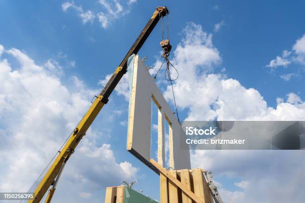 Process Of Crane Construction Of New And Modern Modular House From Composite Sip Panels Against Background With Beautiful Blue Sky Stock Photo - Download Image Now