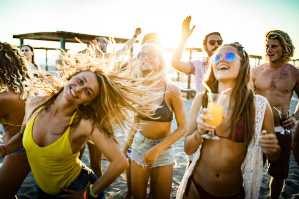 istock Young cheerful people dancing on a beach party at sunset. 1150260718