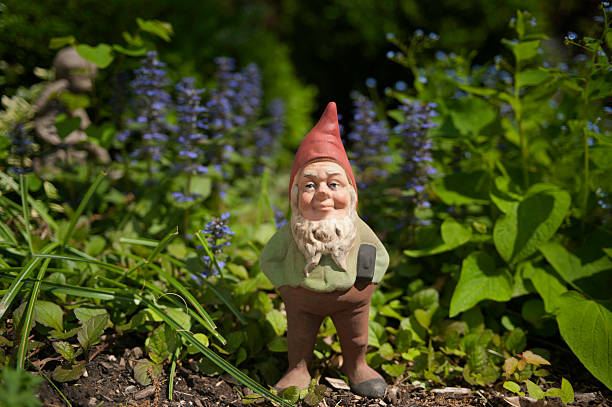 Gnome in the garden Garden gnome with hammer in the foliage Gnome stock pictures, royalty-free photos & images