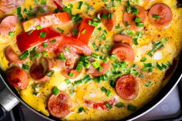 istock Omelette with tomato, onion and sausage on frying pan 1150267103