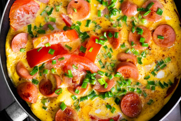 istock Omelette with tomato, onion and sausage on frying pan 1150267106