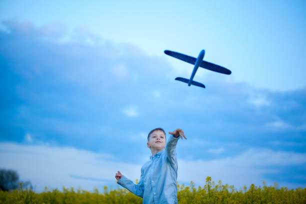 istock Boy throwing toy airplane in summer day. 1150267412