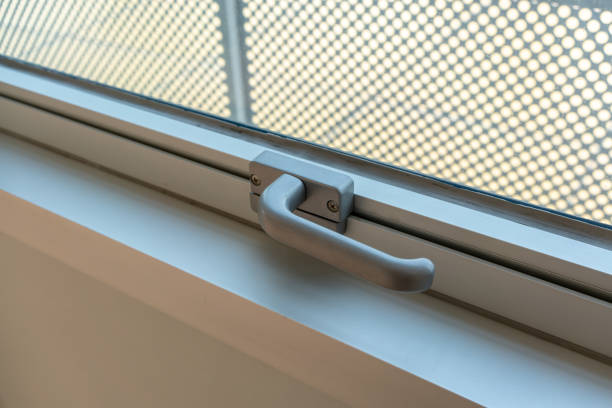 istock Window lock handle in grey color with two screw bolt on white wall. 1150275613