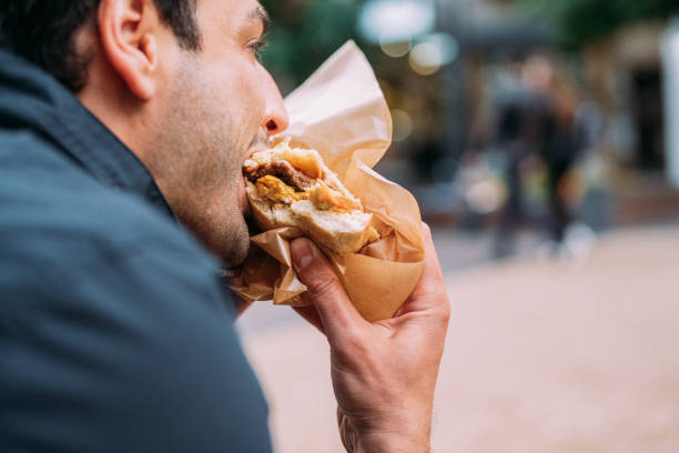 istock Young man eating street burger 1150276472
