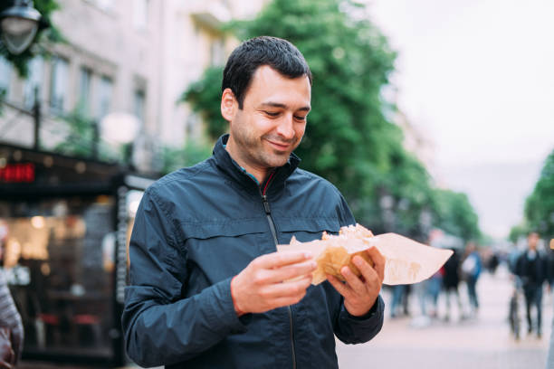 istock Young man eating street burger 1150276474