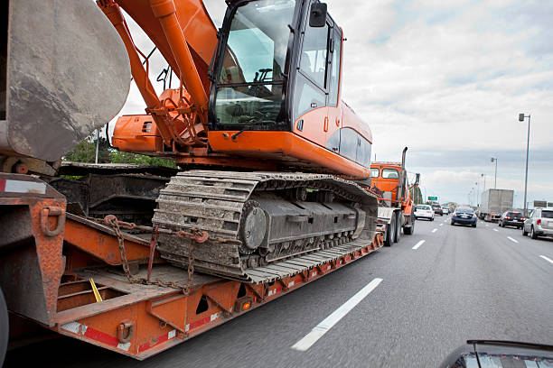 Heavy Equipment Transport Flatbed Transport Truck Carrying Heavy Equipment. road scraper stock pictures, royalty-free photos & images