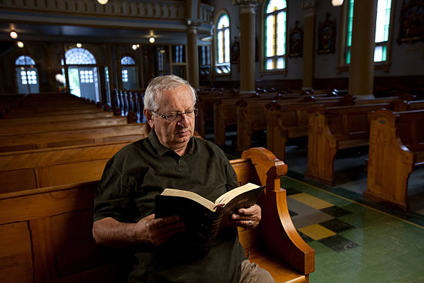 istock Man reading a bible in church 115027808