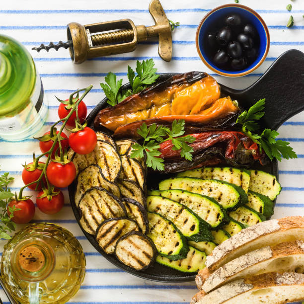 istock grilled vegetables on the table with white wine, fresh bread and aromatic herbs. summer menu 1150278155