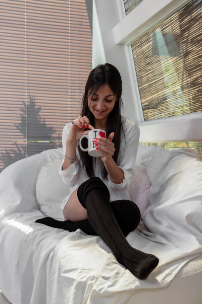 istock Young woman having breakfast on a sofa at home 1150284787