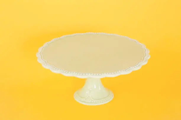 Vintage cake stand on yellow background