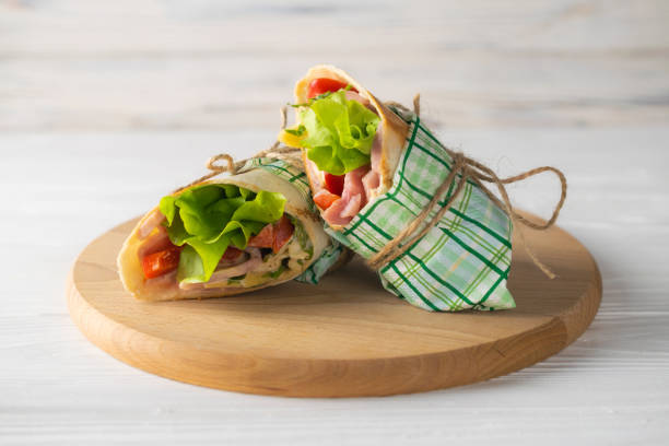 istock Shaurma wrapped sandwich with lettuce tomatoes ham and cheese 1150290391