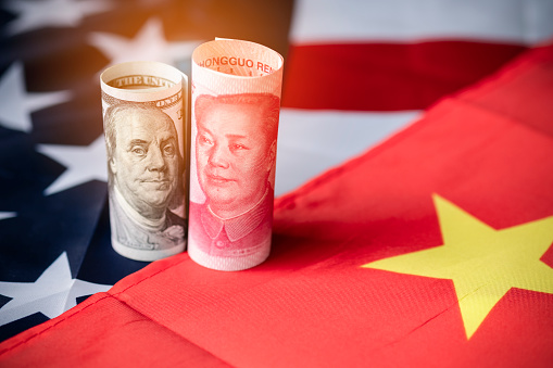 Billete de dólar estadounidense y Yuan en banderas de EE.UU. y China. Es símbolo de la crisis de guerra comercial arancelaria entre los Estados Unidos de América y China, que es el país económico más grande del mundo. photo