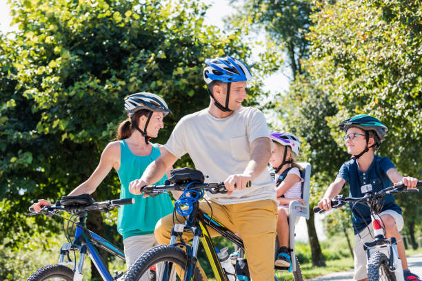istock Family Riding Bicycle In Park 1150293488