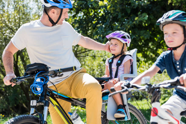 istock Family Riding Bicycle In Park 1150293609