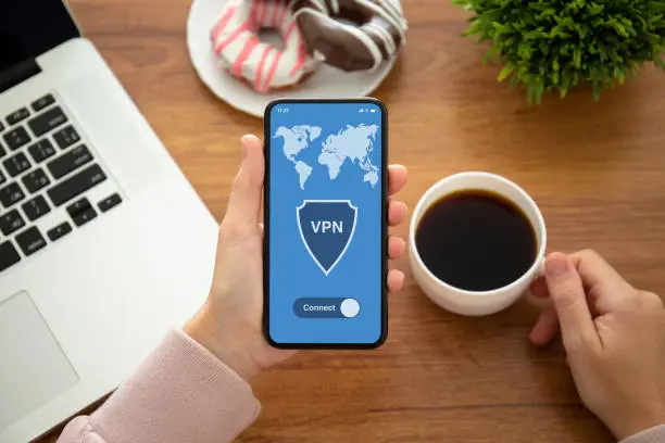 Photo of female hands holding phone with app vpn on the screen