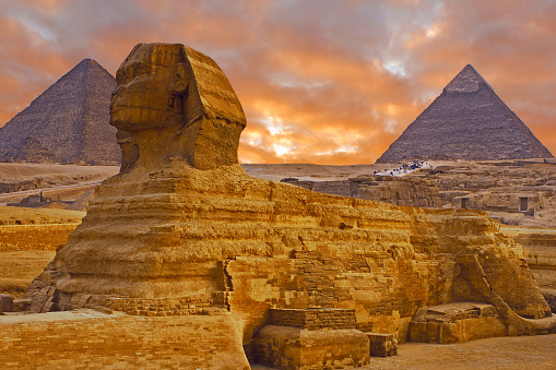 The Sphinx next to the Pyramids in the sands of Giza desert, Egypt.