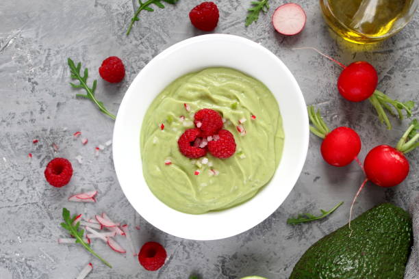istock Homemade avocado smoothie served with raspberries on light background. 1150301753