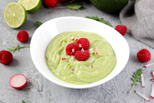 istock Homemade avocado smoothie served with raspberries on light background. 1150301775
