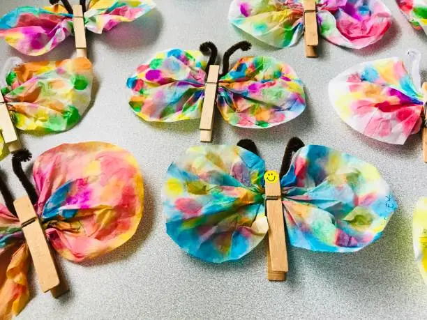 Kids project. Colorful butterflies made from coffee filters, clothespins and pipe cleaners.