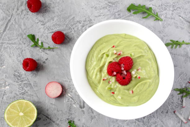 istock Homemade avocado smoothie served with raspberries on light background. 1150302515