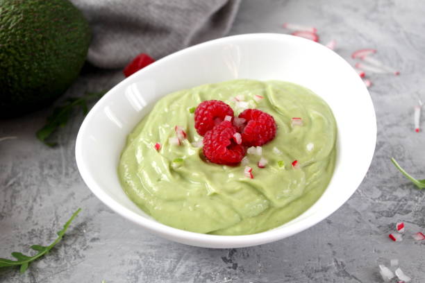 istock Homemade avocado smoothie served with raspberries on light background. 1150302548