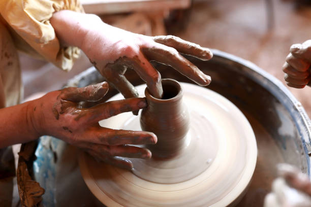 istock Person makes clay pot on potters wheel 1150303634