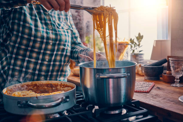 家庭用キッチンでスパゲッティ・ボロネーゼを準備 - tomato sauce domestic kitchen meat cheese ストックフォトと画像