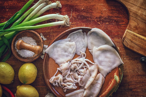 istock Cleaning and Cutting Fresh Squid on a Wooden Cutting Board 1150305096