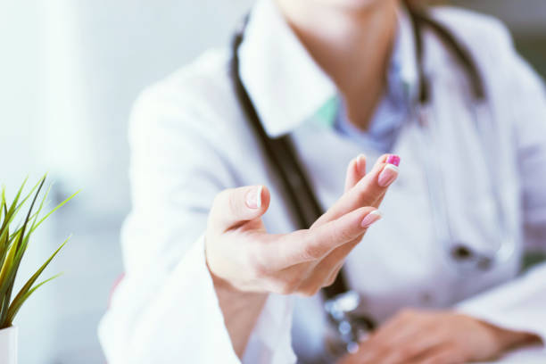 istock Female doctor explaining patient symptoms or asking a question as they discuss together in a consultation. Just hands over the table. 1150307752