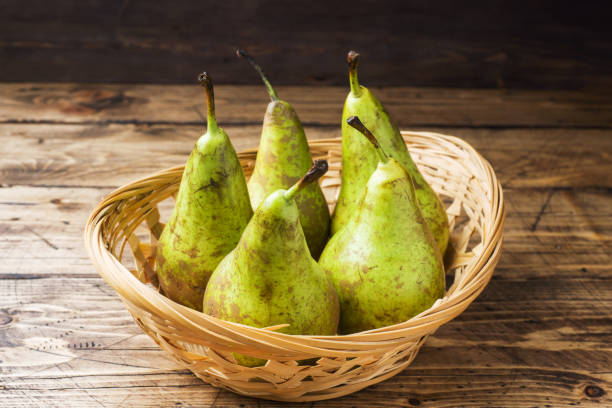 Fresh juicy Pears Conference in a basket on a wooden rustic background. Fresh juicy Pears Conference in a basket on a wooden rustic background conference pear stock pictures, royalty-free photos & images