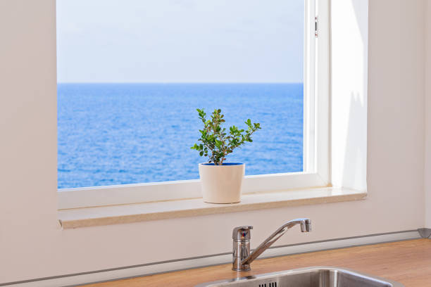 вид на морской пейзаж через открытое окно на кухне - window light window sill home interior стоковые фото и изображения