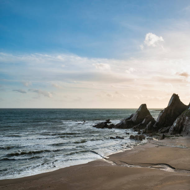 istock Stunning sunset landscape image of Westcombe Beach in Devon England with jagged rocks on beach and stunning cloud formations 1150310992