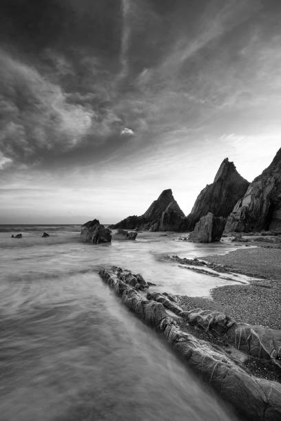 istock Stunning sunset landscape image of Westcombe Beach in Devon England with jagged rocks on beach and stunning cloud formations 1150311398