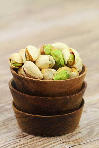 istock Pistachio nuts in brown wooden bowl with copy space 1150312382