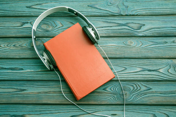 istock Headphones, book on wooden background 1150315242