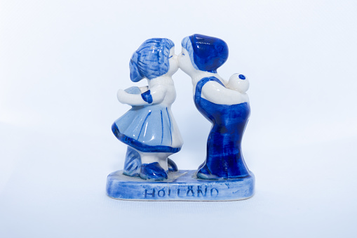 Delft Blue Figurine of kissing Dutch couple. Souvenir from Holland/Netherlands. Isolated on white background.