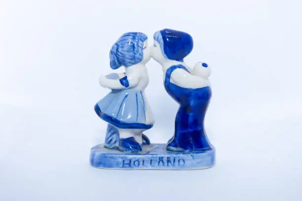 Photo of Delft Blue Figurine of kissing Dutch couple. Souvenir from Holland/Netherlands. Isolated on white background.