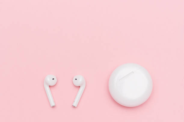 istock White wireless Bluetooth headphones and charging case on pink paper background. Template for text or your design. Flat lay Top view Copy space 1150319268