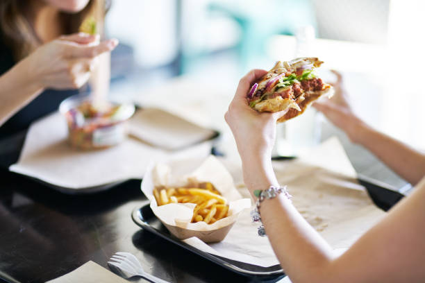 istock woman eating eating vegan meatless burger in restaurant 1150322607