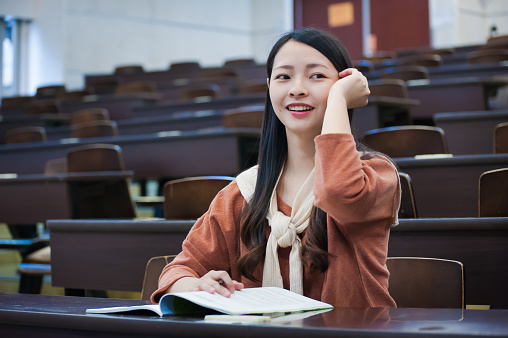 Female student enjoy lecture class in university auditorium