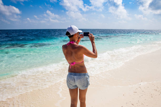 istock Adult Woman Capturing an Image Using Phone on Tropical Beach Vacations 1150329381