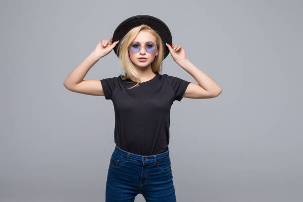 istock Young brunette in black hat and sunglasses isolated on gray background 1150330876