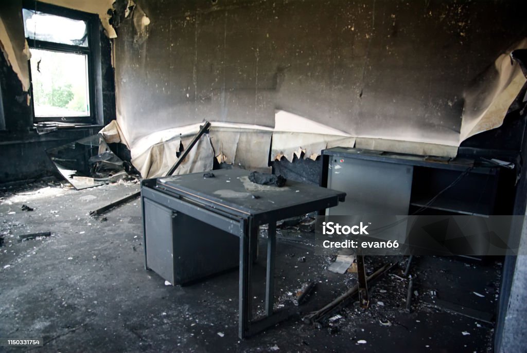 Burned interiors and furniture in industrial building Burned interiors and furniture in industrial or office building. Fire consequences concept. Office Stock Photo