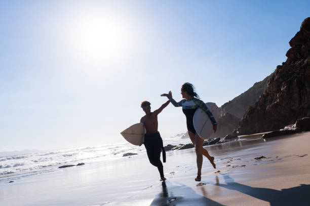 istock Happy surfers giving each other a high-five at beach in summer 1150333061