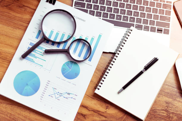 istock Top view,Business desk with a notebook, report graph chart, pen and tablet on wooden table 1150334079