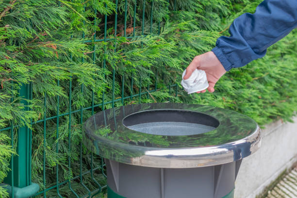 istock Teen volunteer in a blue jacket windbreaker throws collected plastic trash in a container 1150334463