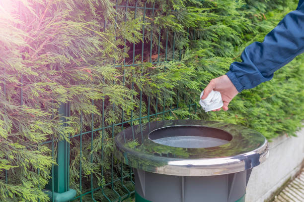 istock Teen volunteer in a blue jacket windbreaker throws collected plastic trash in a container 1150334465